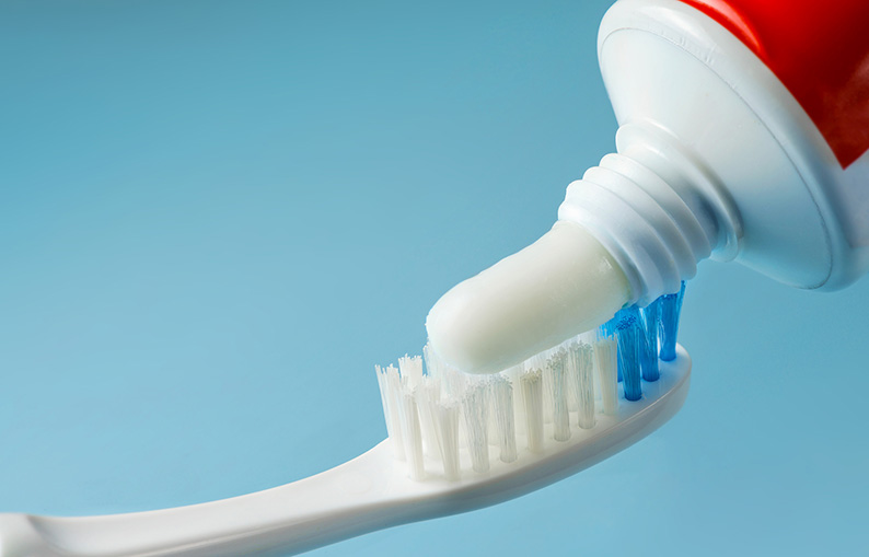 Toothpaste applied to toothbrush bristles 